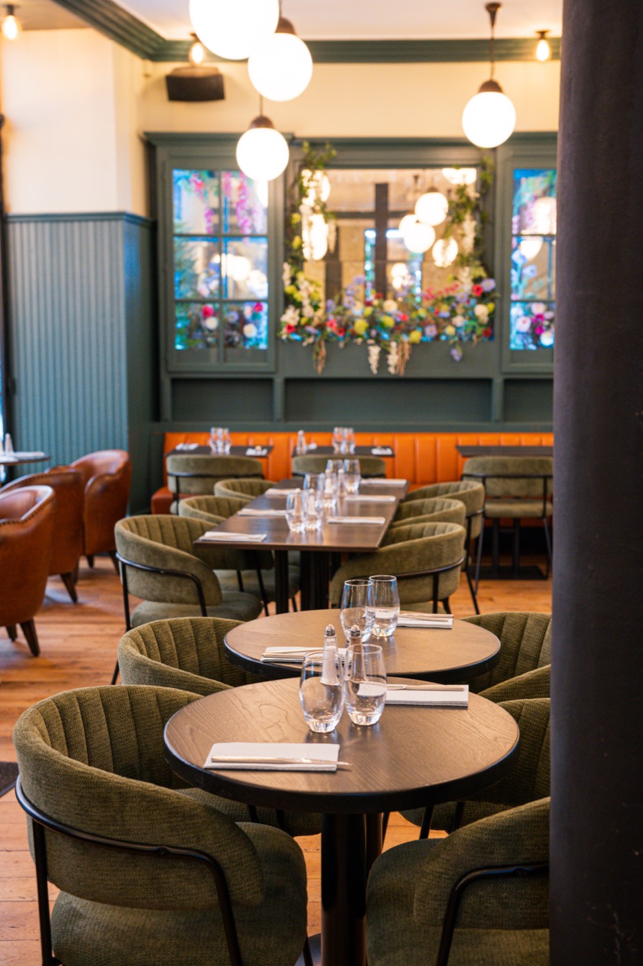 Round tables and opaline glass pendants at Bistrot Jad